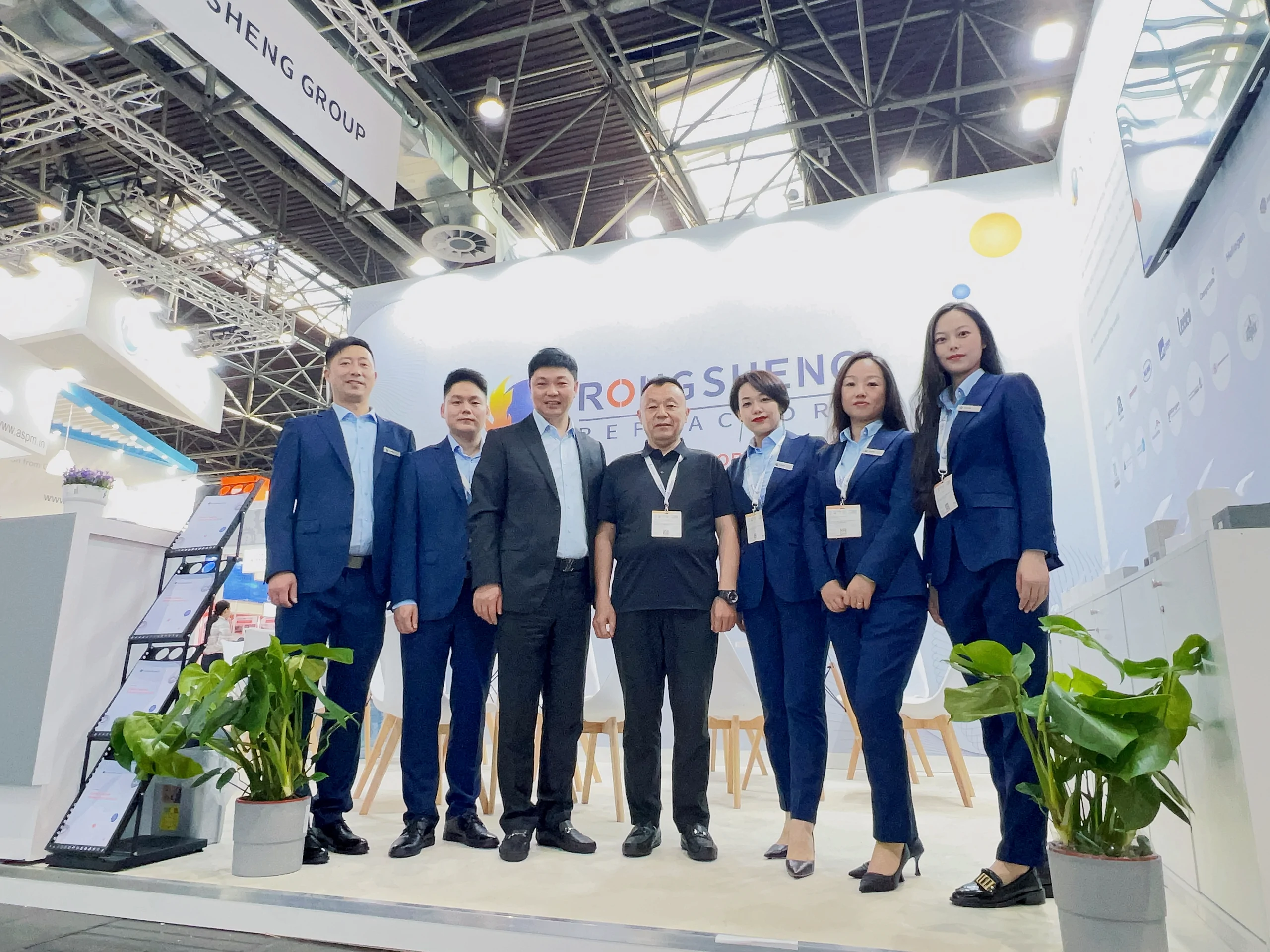 RISING REFRACTORY team standing at the company exhibition booth inside an international trade exhibition hall
